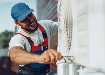 Young black man repairman checking an outside air conditioner unit